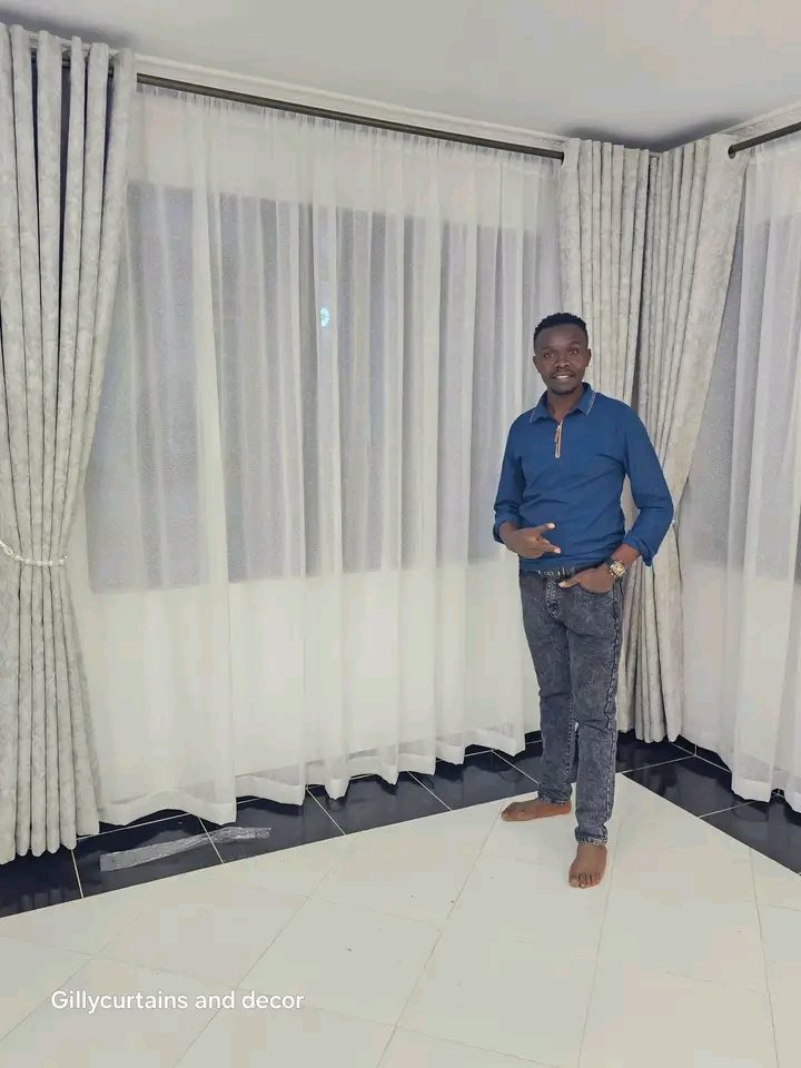 Gilly Interiors team member in front of freshly installed curtains